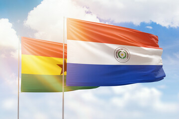 Sunny blue sky and flags of paraguay and ghana