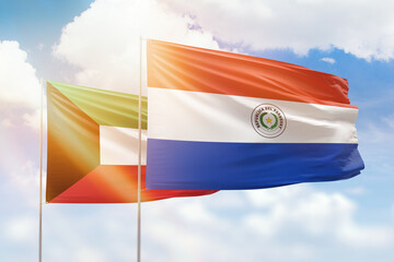 Sunny blue sky and flags of paraguay and kuwait