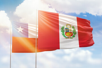 Sunny blue sky and flags of peru and chile