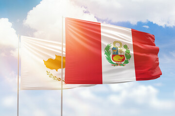Sunny blue sky and flags of peru and cyprus