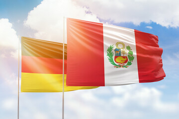 Sunny blue sky and flags of peru and germany