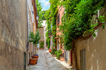 A charming, picturesque narrow street in the medieval village of Grimaud, France, in the hills above Saint-Tropez along the French Riviera.