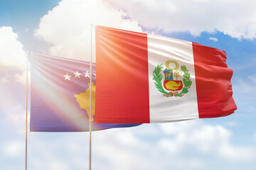 Sunny blue sky and flags of peru and kosovo