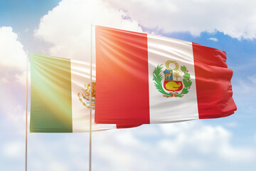 Sunny blue sky and flags of peru and mexico