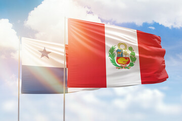 Sunny blue sky and flags of peru and panama