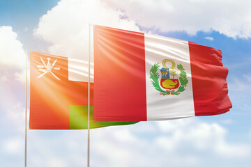 Sunny blue sky and flags of peru and oman