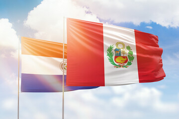 Sunny blue sky and flags of peru and paraguay