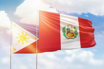 Sunny blue sky and flags of peru and philippines
