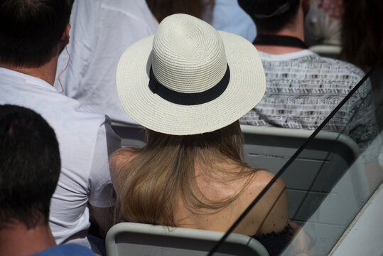 Portrait on back view of young woman wearing a summer hat in a cruiser boat