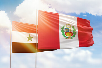 Sunny blue sky and flags of peru and syria