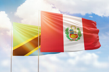 Sunny blue sky and flags of peru and tanzania