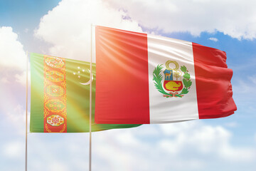 Sunny blue sky and flags of peru and turkmenistan