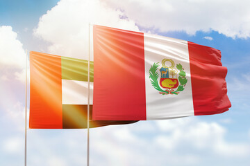 Sunny blue sky and flags of peru and uae