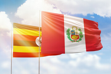 Sunny blue sky and flags of peru and uganda
