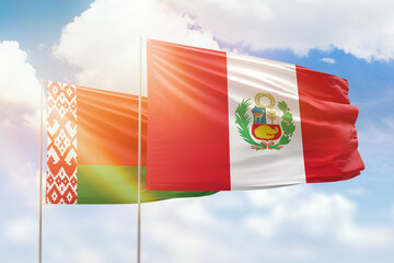 Sunny blue sky and flags of peru and belarus
