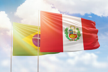Sunny blue sky and flags of peru and brazil