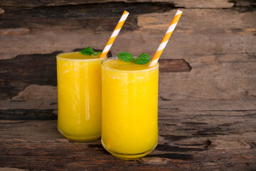 Mango juice fruit smoothies yogurt drink yellow healthy delicious taste in a glass slush for weight loss on wooden background.