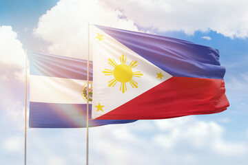 Sunny blue sky and flags of philippines and el salvador