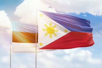 Sunny blue sky and flags of philippines and estonia