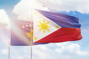Sunny blue sky and flags of philippines and kosovo