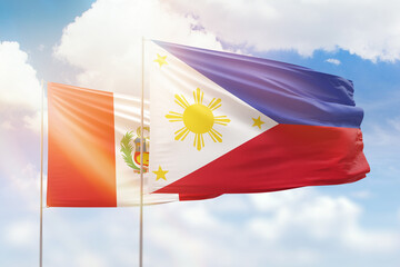 Sunny blue sky and flags of philippines and peru