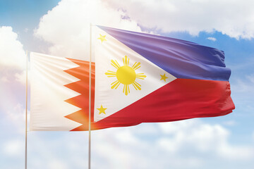 Sunny blue sky and flags of philippines and bahrain