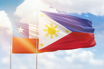 Sunny blue sky and flags of philippines and chile