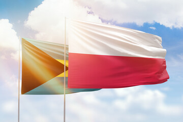 Sunny blue sky and flags of poland and bahamas