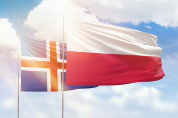 Sunny blue sky and flags of poland and iceland