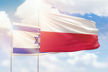 Sunny blue sky and flags of poland and israel