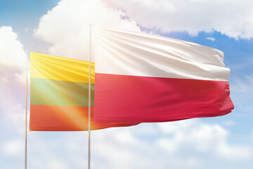 Sunny blue sky and flags of poland and lithuania