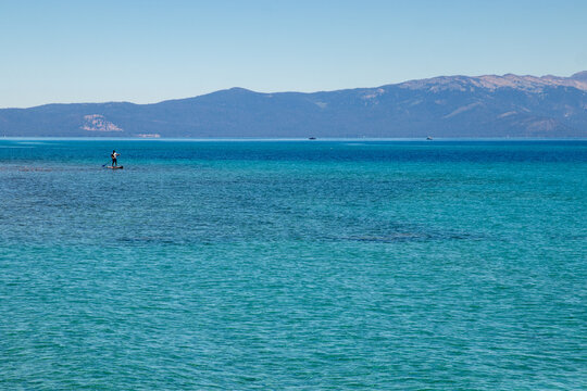Standup paddleboarder enjoys the blue water of Lake Tahoe
