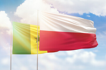 Sunny blue sky and flags of poland and senegal