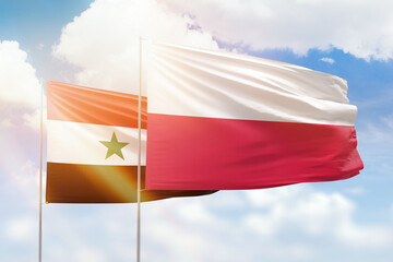 Sunny blue sky and flags of poland and syria
