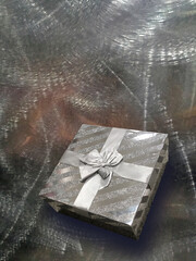 Wrapped gift box on shiny metallic background