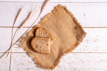 Fototapeta na wymiar Bread ears and pieces of bread on a burlap on the table