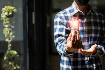Man holding a light bulb, new ideas, technological innovations and creativity. with a sparkling light bulb Concept with innovation and inspiration
