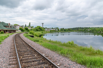 A railway track curves its way around a small lake up to the station in the small former mining...