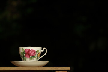 Vintage tea cup against black background