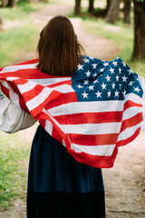 Woman posing with USA national flag standing outdoors . Positive girl celebrating United States independence day. - 511803240