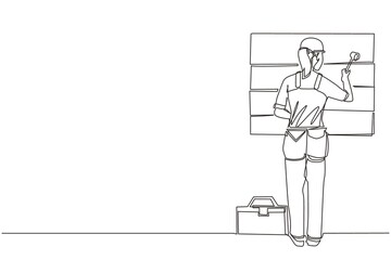 Single one line drawing woman professional worker in uniform hammering. Nail in wood. Construction work at home. Building, construction, repair work service. Continuous line draw design graphic vector