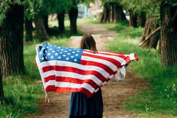 The girl carries the American flag. United States independence day. - 511803269
