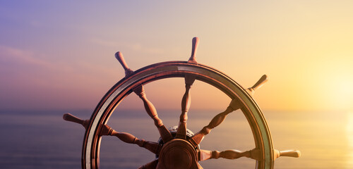 Ship steering wheel, commonly known as helm, with the ocean at sunset in the background. 3D Rendering, illustration - obrazy, fototapety, plakaty