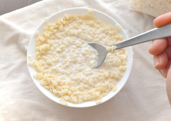 Crispy rice cereal with milk in a white bowl.	
