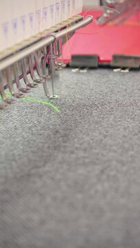 Vertical video, embroidery machine. Engaged in embroidery with threads