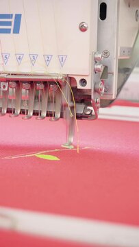 Vertical video, embroidery machine. Engaged in embroidery with threads
