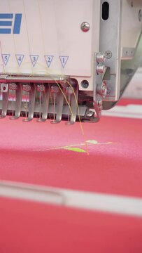 Vertical video, embroidery machine. Engaged in embroidery with threads
