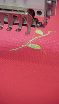 Vertical video, embroidery machine. Engaged in embroidery with threads