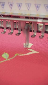 Vertical video, embroidery machine. Engaged in embroidery with threads