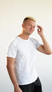 Male confidence. Barber shop. Metrosexual lifestyle. Self admiration. Vertical portrait of narcissist blond man in white walking stopped by to check haircut showing thumb up isolated on light loop.